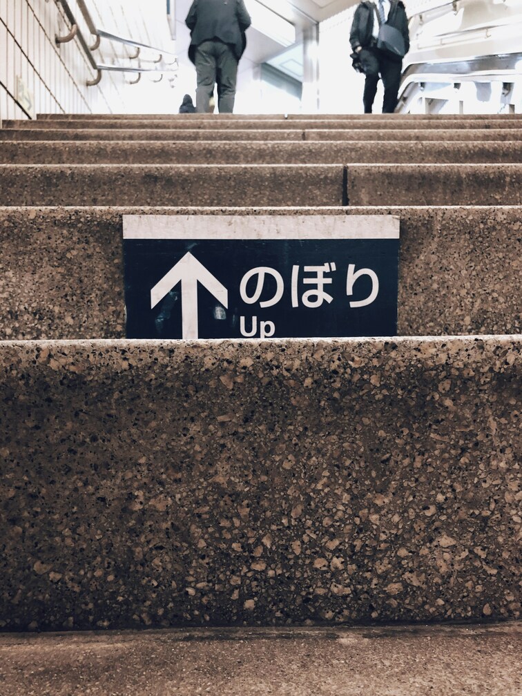 東京の駅の階段を昇る通勤者たち