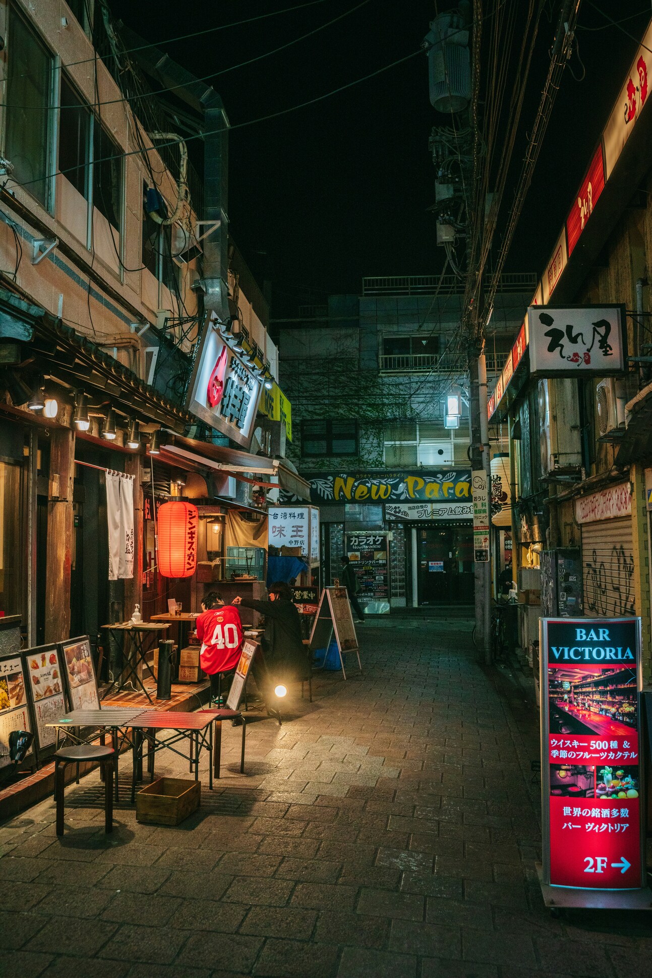 夜の横丁に並ぶ小さなバーと居酒屋